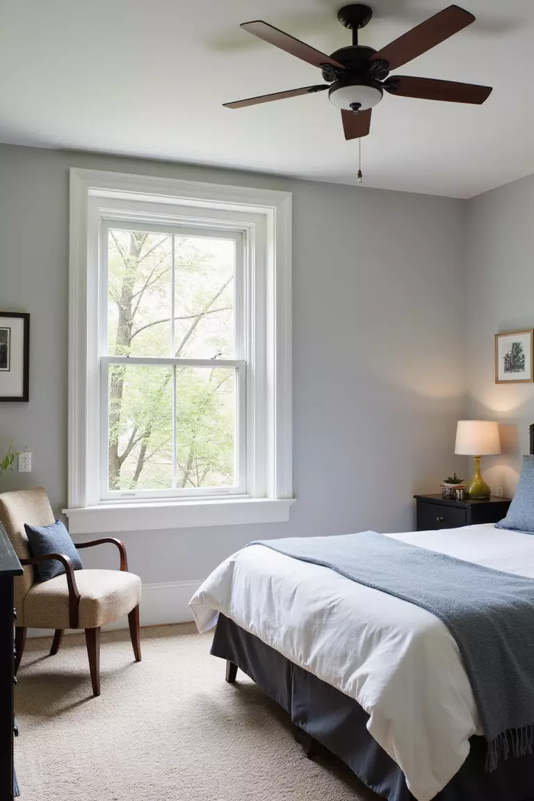 Ensure Good Airflow A professional photo, similar to a photo in a home design magazine, of a guest bedroom with a slightly open window letting in fresh air, and a stylish ceiling fan.