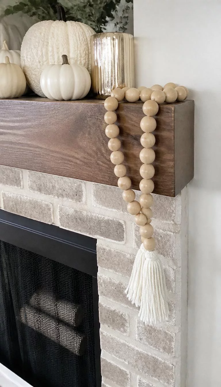 A super-realistic photo of a fireplace mantle featuring a long strand of large raw light wood beads draped over the corner, ending in white tassels, resting alongside some small white pumpkins, everyday social media post aesthetic, photorealistic, high-quality mobile photography, shot on an iPhone 14